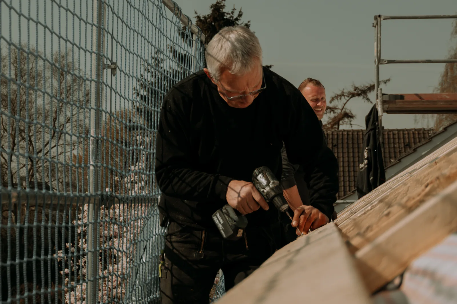 Dachdecker befestigt die Lattung auf einer gedämmten Dachfläche