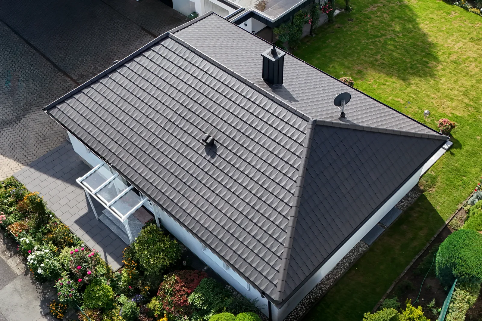 Drohnenaufnahme eines sanierten Daches mit anthrazitfarbenen Designerziegeln